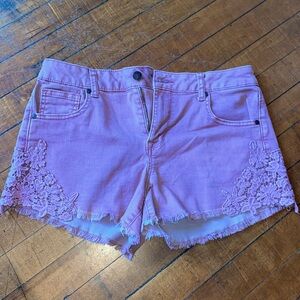 Stretchy mauve shorts with flower embroidery and fringe hem
